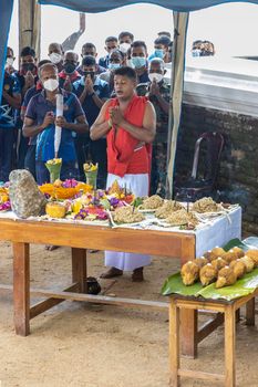 Anuradhapura Sri Lanka - december 6 2021: a sacred rite of prayer near a Buddhist temple. People are standing in front of a table with fruit and praying. A priest and musicians are present. High quality photo