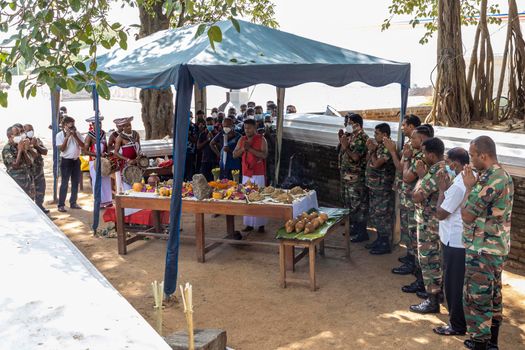 Anuradhapura Sri Lanka - december 6 2021: a sacred rite of prayer near a Buddhist temple. People are standing in front of a table with fruit and praying. A priest and musicians are present. High quality photo
