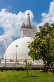 The Ruwanweli Maha Seya, also known as the Mahathupa (the Great Thupa) is a stupa in Anuradhapura, Sri Lanka. Popular attraction. View from garden with beautiful trees. High quality photo