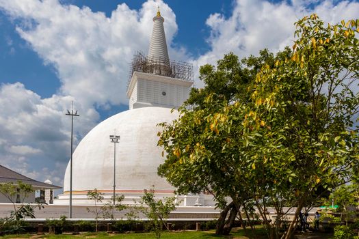The Ruwanweli Maha Seya, also known as the Mahathupa (the Great Thupa) is a stupa in Anuradhapura, Sri Lanka. Popular attraction. View from garden with beautiful trees. High quality photo