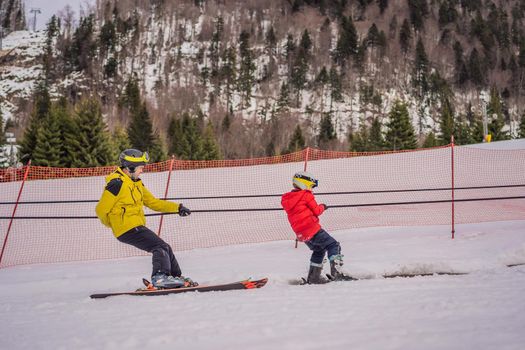 Instructor teaches boy skier to use on ski lift.