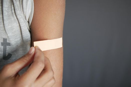 adhesive bandage on young man's arm .