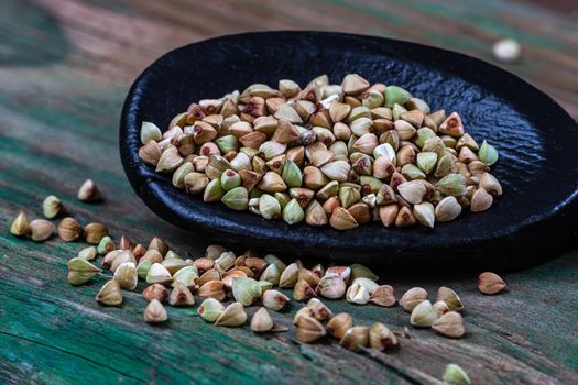 Sarasin seeds in macro in a wooden spoon on a green background