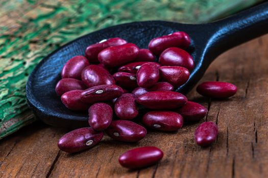Red beans in close-up in a wooden spoon