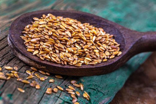 Flaxseeds in close-up in a tone-on-tone spoon.