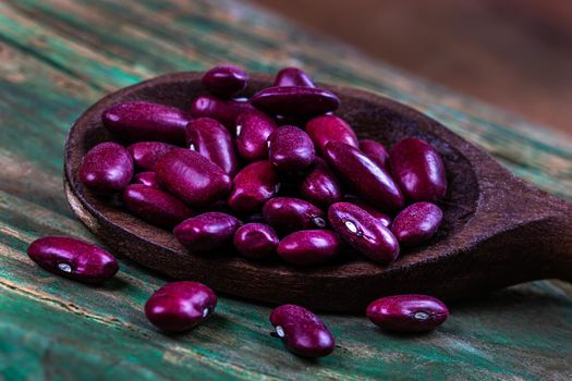 Red beans in close-up in a wooden spoon