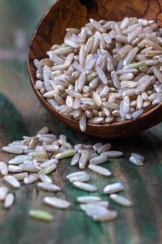 Rice grains in macro in a wooden spoon.