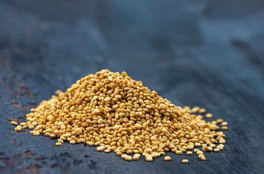 Heaps of Quinoa grains in close-up on a dark background