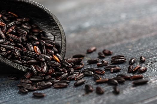 Rice grains in macro in a wooden shovel spoon