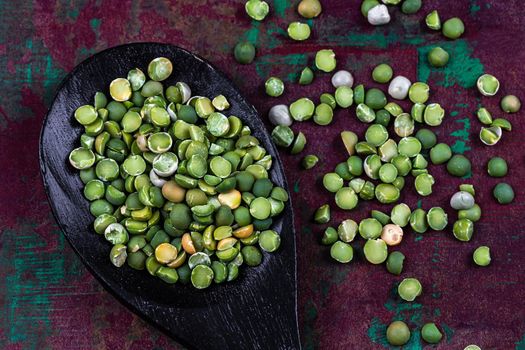 Peas scattered on a foce bottom on wooden spoon