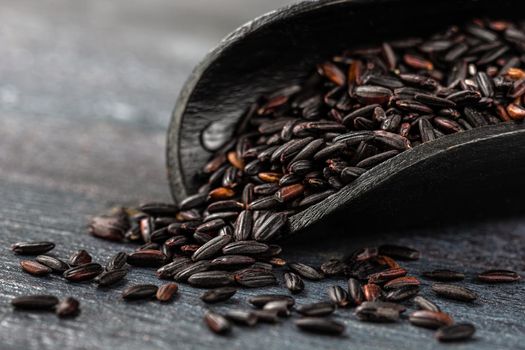 Rice grains in macro in a wooden shovel spoon