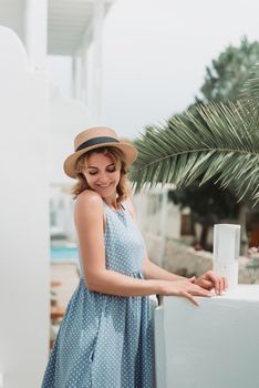 Travel Europe for summer holiday. Portrait of beautiful woman visitting old villages in Greecem with sun hat and summer dress.