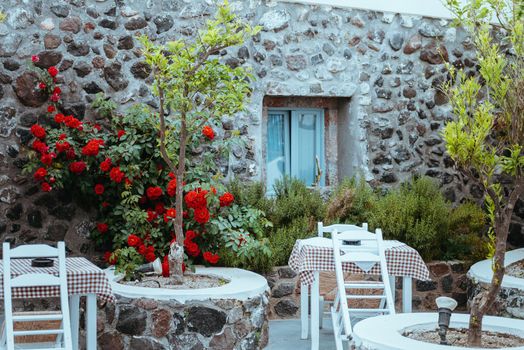 Cafe terrace in small European city at sunny summer day. Cafe with tables and chairs in an old street in Europe.