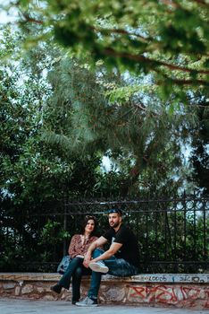 Athens, Greece, May 21, 2019: Park outdoor young loving couples relaxing on benches editorial
