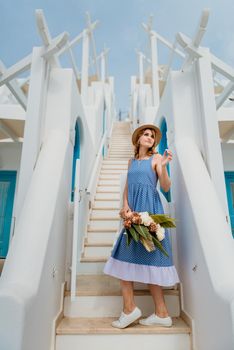 Beautiful girl walking along the street of Santorini island, an old European town, Greece. Portrait of a tourist girl walking on the street background