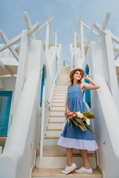 Beautiful girl walking along the street of Santorini island, an old European town, Greece. Portrait of a tourist girl walking on the street background