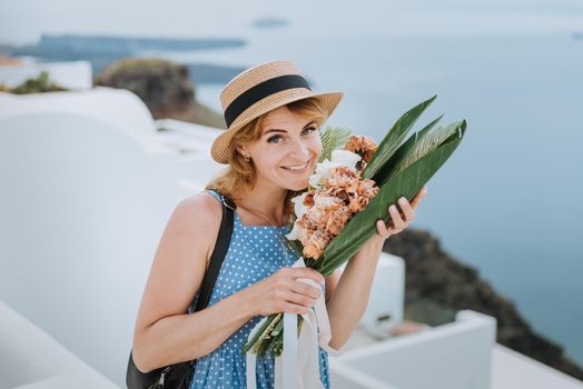 Beautiful girl walking along the street of Santorini island, an old European town, Greece. Portrait of a tourist girl walking on the street background