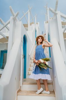 Beautiful girl walking along the street of Santorini island, an old European town, Greece. Portrait of a tourist girl walking on the street background