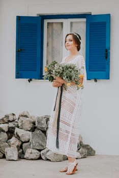 Young attractive bride with the bouquet of flowers.