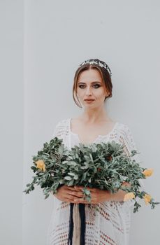 Young attractive bride with the bouquet of flowers.