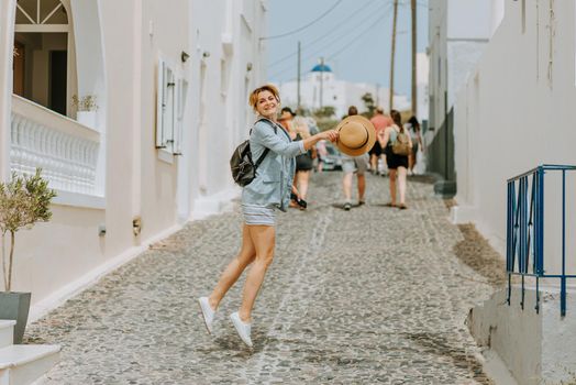 Sunny fashion portrait of happy girl jumping on the street, sunny colors positive mood.