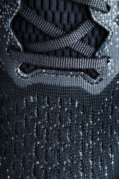 Mesh of black sports sneakers for training close-up in full screen