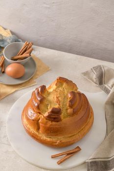 Fogaça on kitchen countertop with eggs and cinammon sticks. Traditional cake from Santa Maria da Feira, Portugal.