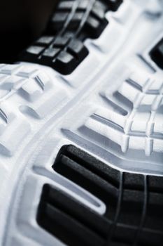 The black and white sole of trendy sports sneakers is a close-up in full screen. Shoe cushioning technology
