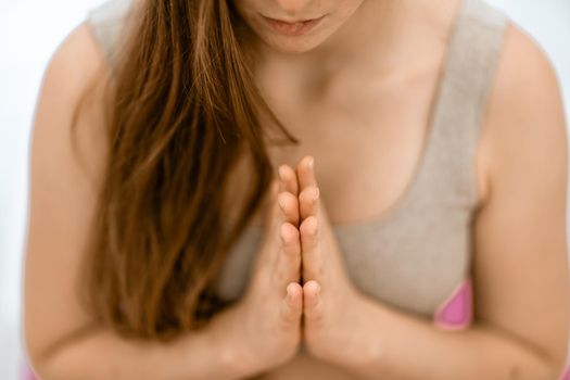 Girl does yoga. Young woman practices asanas on a beige one-ton background