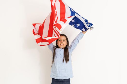 Patriotic holiday. Happy kid, cute little child girl with American flag. USA celebrate 4th of July
