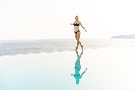 Summer in the city. Happy young woman near swimming pool.