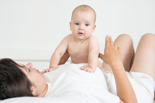 happy mother with baby on bed.