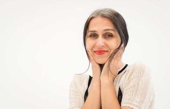 Studio photo of middle aged woman starting getting grey-haired wearing black and white clothes on white background, middle age sexy lady, happy life concept.