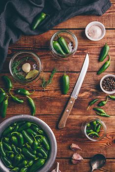 Jalapeno Peppers for Canning with Spices, Garlic and Glass Jars on Wooden Table. View from Above