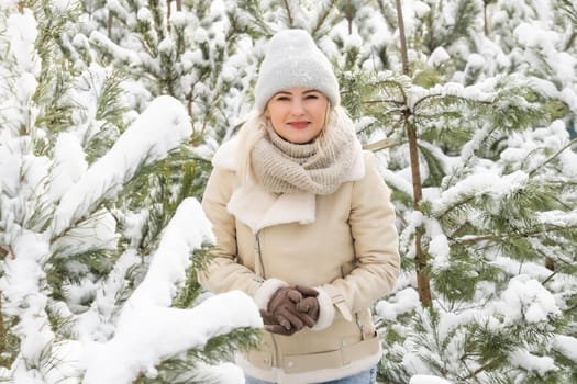 Young laughing happy Caucasian woman, pine branches in winter forest. Positive emotions, walking in snowy weather