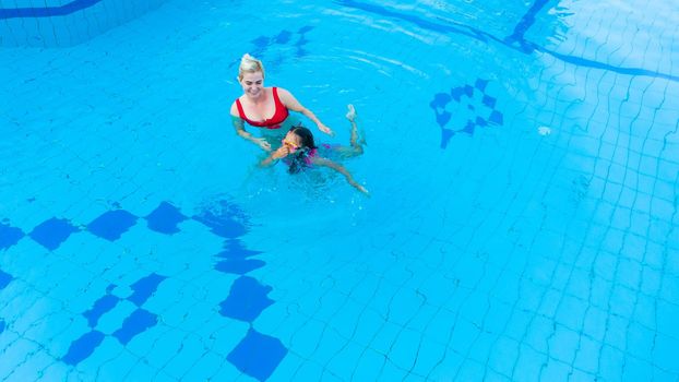 happy little girl and mother in pool.