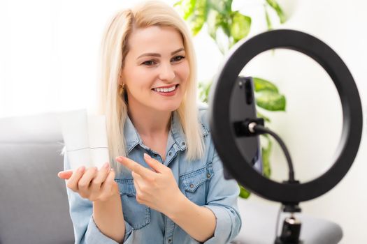 blogger woman records video with round lamp.