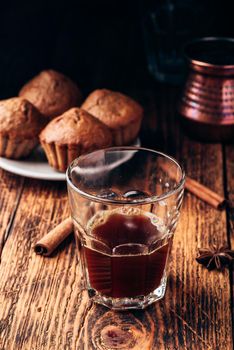 Turkish coffee with spices and oatmeal muffins on wooden surface