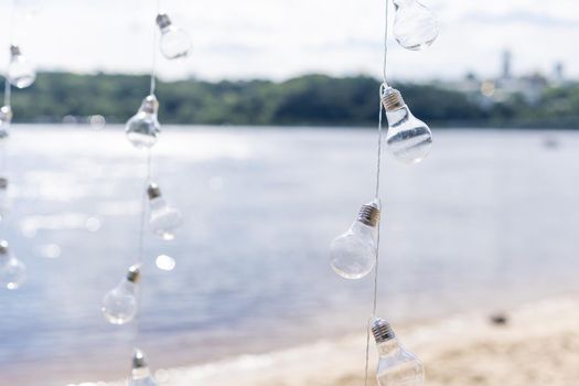 Hanging light bulbs on a background of water.