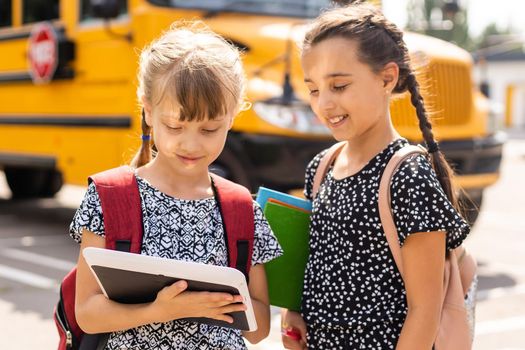 Lucky to meet each other. Cheerful smart schoolgirls. Happy schoolgirls outdoors. Small schoolgirls wear school uniform. Cute schoolgirls looking charming. Ending of school year