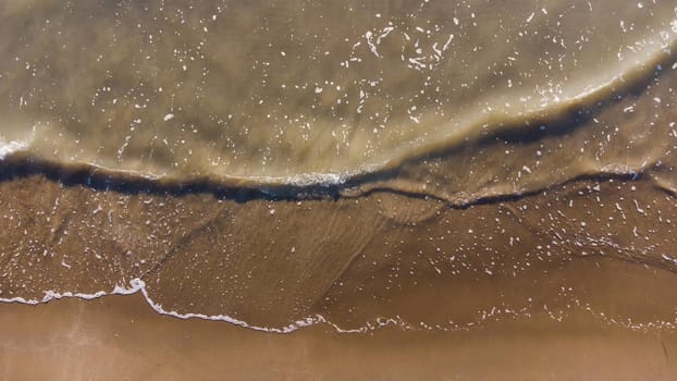 Top view of texture waves sandy beach