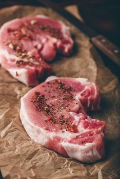 Pork loin steaks with ground spices on baking paper