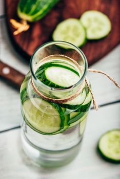 Infused water with sliced cucumber in glass bottle