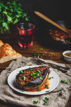 Baked eggplant stuffed with ground beef, tomatoes and spices on white plate. Traditional dish Karniyarik of turkish cuisine