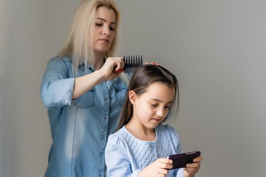 Mother treating daughter's hair against lice.