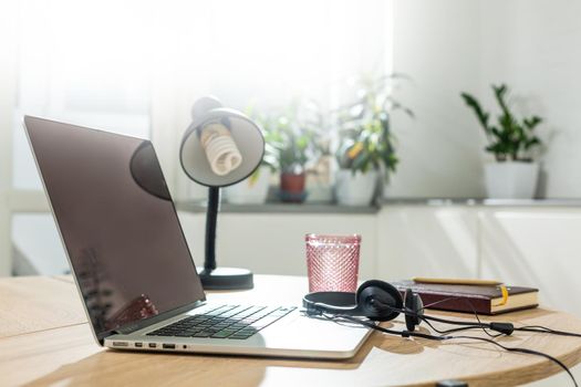 Working from home - a laptop and an organizer on a kitchen table with kitchen in the background.