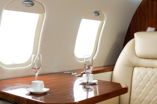 Cabin of luxury private jet. Empty aircraft with white leather chairs