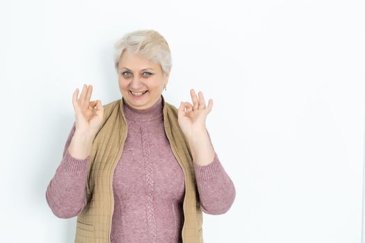 Happy old woman showing OK. isolated on white.