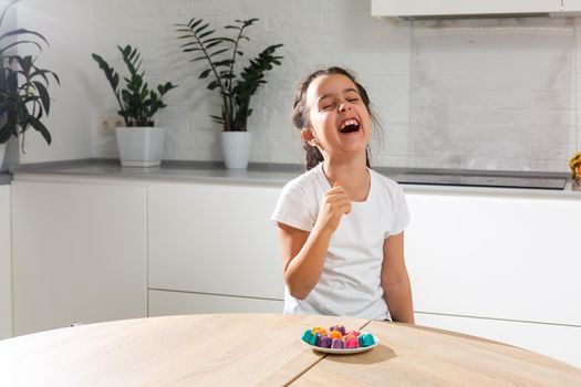 Small girl celebrating Holi Festival of Colors holding tray in hand.