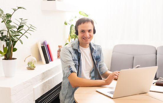 Man Using Laptop On Desk At Home